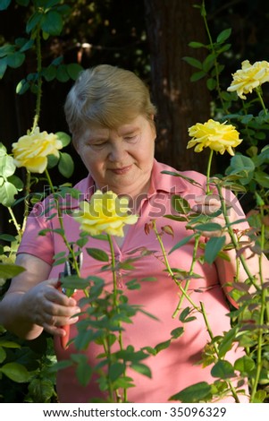 Happy elderly lady enjoys her time in a garden.