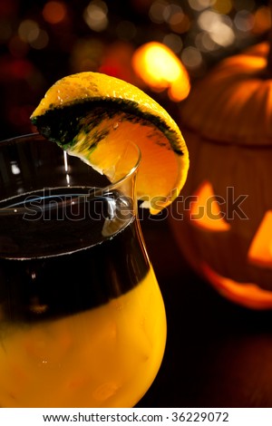 Closeup of Rotten Pumpkin Cocktail, black vodka, orange juice - Halloween drinks series