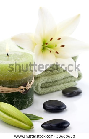 Aromatherapy lily spa set -  lily flowers, aroma candle, spa stones and and towels over white background best suited for relaxing and health commercials