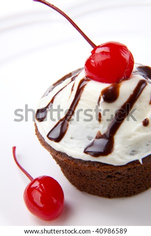 Closeup of fresh baked home made chocolate cherry cupcake isolated on white and maraschino cherry.