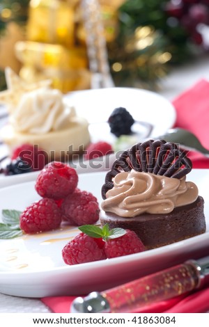 Delicious chocolate cheesecake served with fresh raspberries, Vanilla Bean Cheesecake and Christmas ornament out of focus