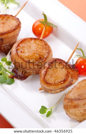 Ginger Soy Scallops wrapped by bacon garnished with fresh cherry tomatoes and daikon sprouts.