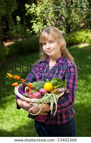 Teenage girl holding a basket of fruits and vegetables.