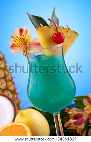 Blue Hawaiian cocktail surrounded by tropical fruits. Rum, pineapple juice, coconut milk and blue curacao garnished with slice of pineapple and maraschino cherry. Most popular cocktails series.