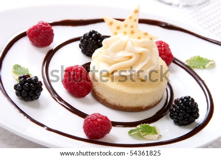 Delicious Vanilla Bean Cheesecake served with fresh blackberries and mint.