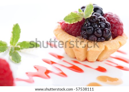 Closeup of delicious fresh berry cake garnished with pineapple mint