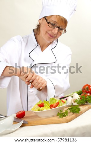Executive chef preparing fresh organic salad, pouring dressing