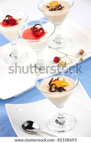 Closeup of Strawberry Panna Cotta Dessert garnished with Alpine strawberries, and chocolate shavings.