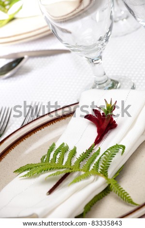 Exotic theme table setting. Arrangments with fresh fern and kangaroo paws flower