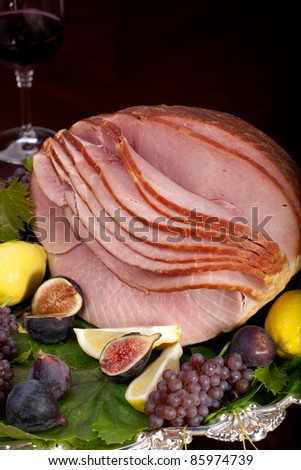 Glazed delicious whole baked honey sliced ham with figs, lemons and champagne grapes.