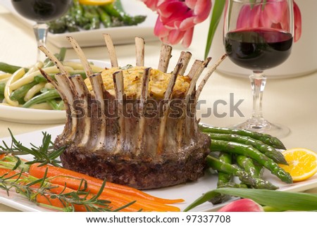 Crown roast of lamb with apple rosemary stuffing. Garnished with asparagus, glazed carrots, and rosemary twigs. Side dishes - asparagus, and beans.