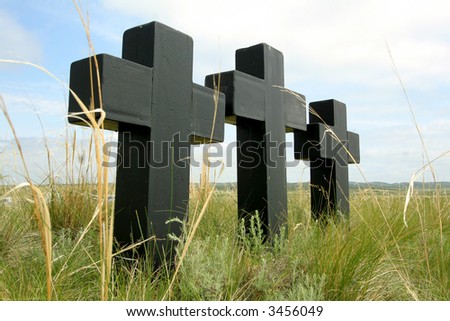 Three black crosses in a grass