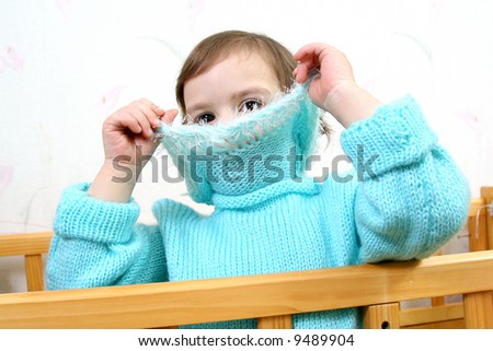 little girl hides face behind collar of jacket