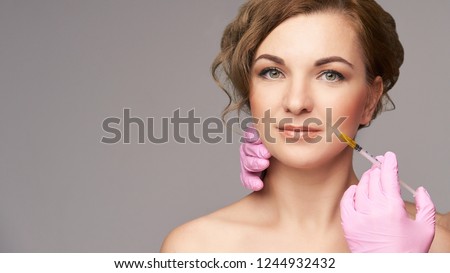 Face needle injection. Young woman cosmetology procedure. Doctor gloves. Lips.