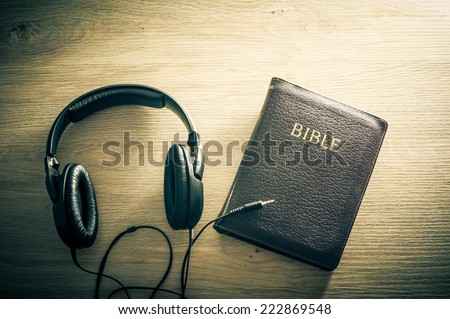Holy Bible with headphones - symbol of listening to the Word of God.