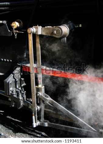 A detail of the rods and gears of a historical steam engine in action.