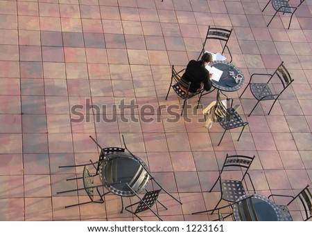 An air perspective on a business woman working at an open air cafe table. With copy space.
