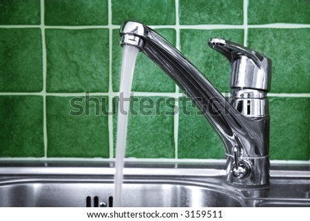 Kitchen water tap and green tiles