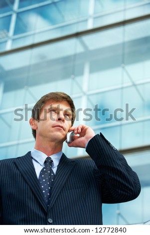 Man outside office building, using cell phone
