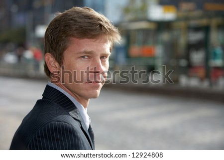 Portrait of man on city street, looking back