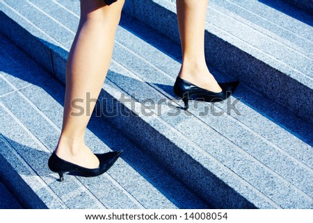 Businesswoman walking up stairs to higher level