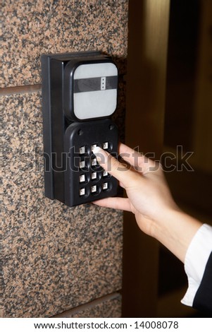 Hand of young businesswoman, entering access code