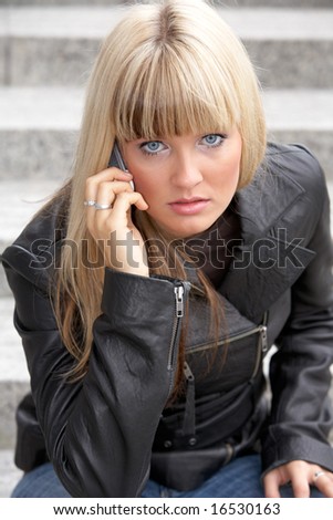 Young woman on mobile phone, looking at camera