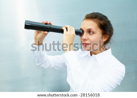 Young woman using telescope outside building wall