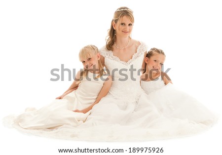Beautiful mother bride with two young daughters. They all wear white dresses. Studio shot on white background.