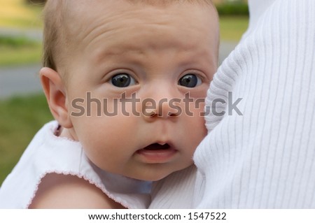 Newborn baby girl with wrinkled forehead and pensive / amused expression.