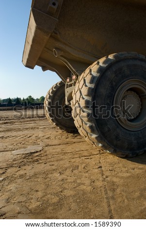 Massive tires on a giant truck used on a highway construction site.