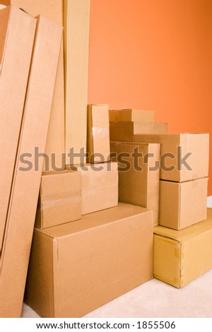 Moving boxes piled high. Related themes include moving into a new home or dorm, receipt of many christmas gifts to be wrapped, or business shipping and freight.