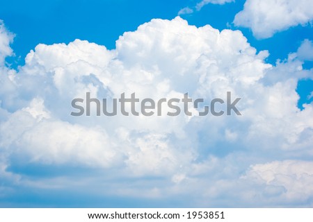 Tall bank of thunderhead clouds builds above the horizon. Deep blue sky can still be seen above them. Beautiful calm before the storm. Good desktop background or design element.