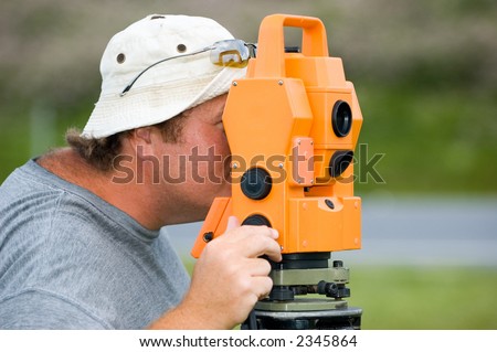A land surveyor looks throw the eye piece of an electronic distance meter. The instrument is used to measure angles and distances to extreme accuracy.