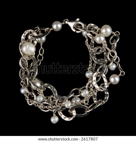 Fancy designer pearl and silver bracelet. Isolated on black background.