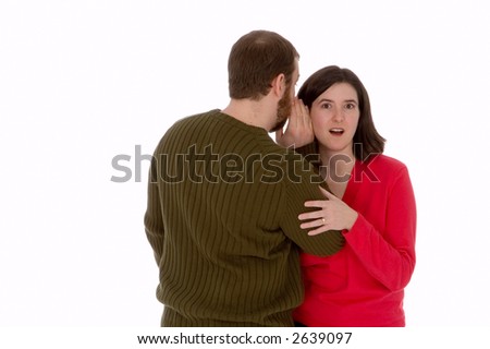 Man whispers into a young womans ear. She is very surprised by what he is telling her.