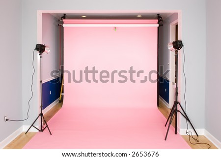 Photography studio setup for a photo shoot with a pink seamless paper background.