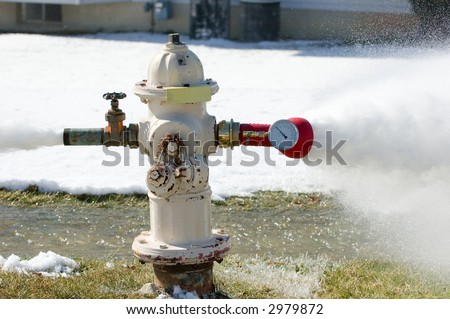 High pressure water streams from both sides of a fire hydrant during a pressure check.