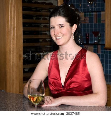 Brunette Bridesmaid in red dress standing behind the bar.