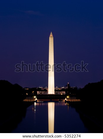 Washington Monument in Washington, DC, beautifully illuminated at night and reflecting in the reflecting pool. As seen from the steps of the Lincoln Memorial.