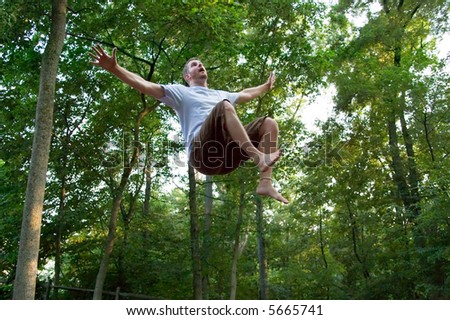 Young man appears to be floating in mid-air, looking upward, with startled expression. Is it an alien abduction or is he falling from the sky?