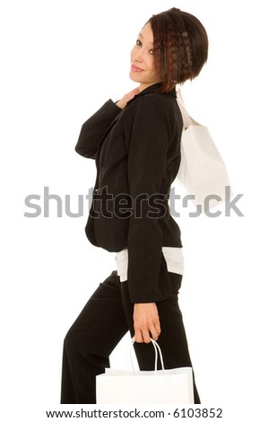 Woman in pants suit shopping with one page slung over her shoulder and another in her left hand.