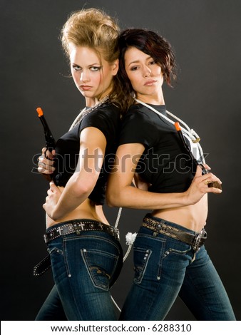 Two models in striking outfits with toy guns. Expressions convey attitude and feminine power.