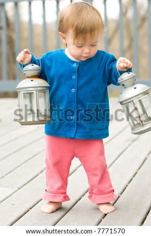 Little girl holding two lanterns, reminiscent of Revolutionary American Paul Revere\'s \