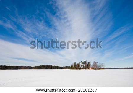 Swedish red house on a frozen snowed lake