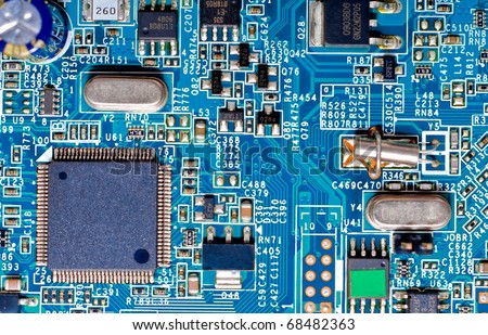 Close-up photograph of the microchips and micro-electronic components on a blue circuit board