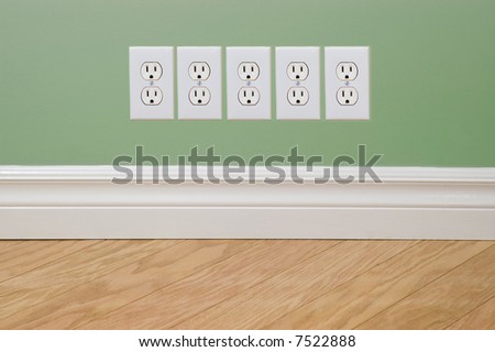 Power outlets on green wall (energy crisis concept)
