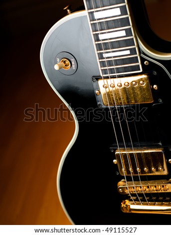 Classic black rock and roll or jazz guitar in soft spotlight. Stage or studio concept ready to perform.