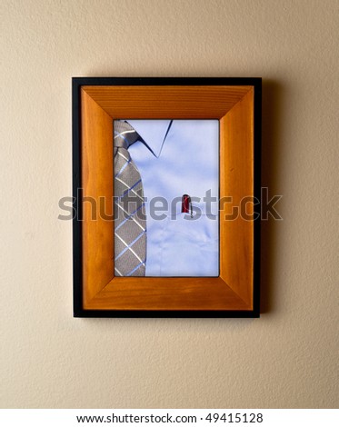 Classic blue dress shirt with red pen. Iconic image of work life in a beautiful wooden frame on wall shows retirement or significance of work concept.