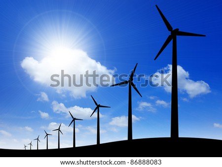 Silhouette of windmills on blue sky background with space